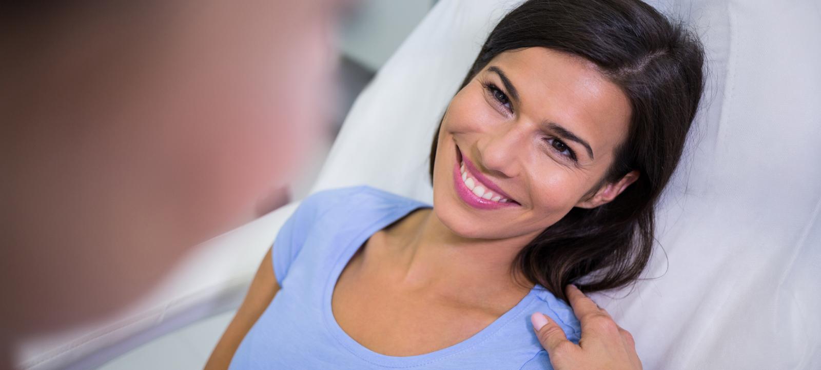 Happy female patient experiencing relief from back pain after seeing a chiropractor.