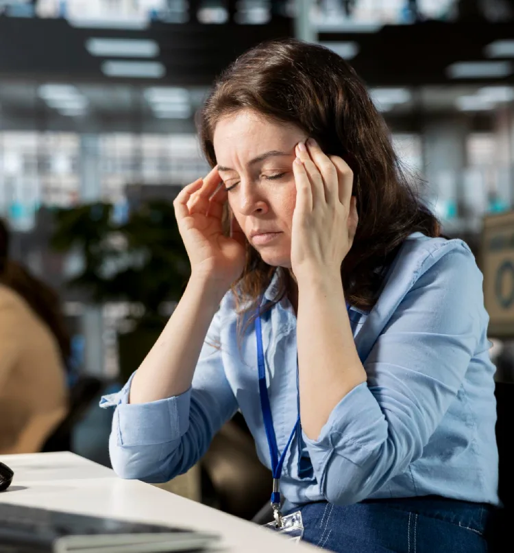 Woman being unwell with a migraine at the office